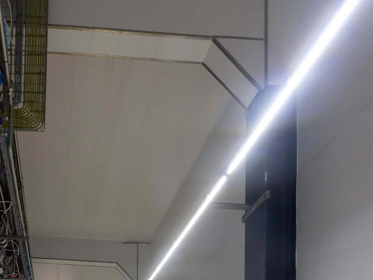 Industriële LED lijnverlichting langs plafond en kabelgoten